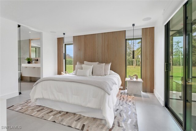 bedroom with access to outside, finished concrete floors, and baseboards