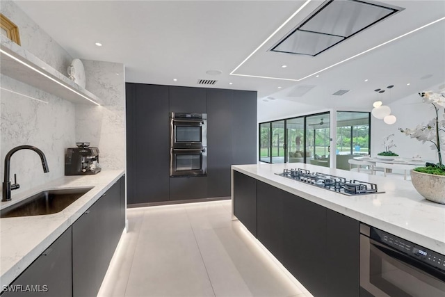 kitchen featuring double oven, modern cabinets, gas cooktop, and a sink