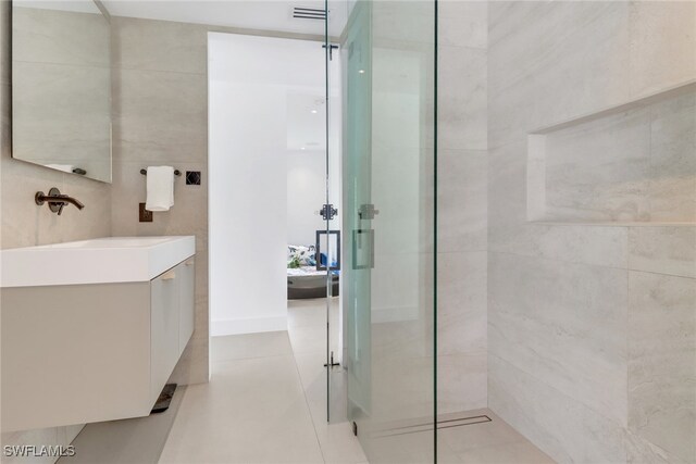 full bathroom featuring tile patterned flooring, walk in shower, tile walls, and vanity