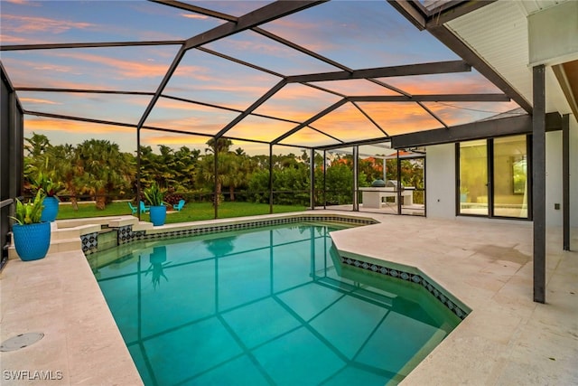 outdoor pool with a lanai, a patio area, and a yard