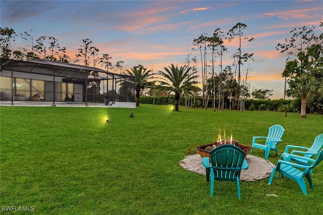 view of yard with a fire pit and a lanai