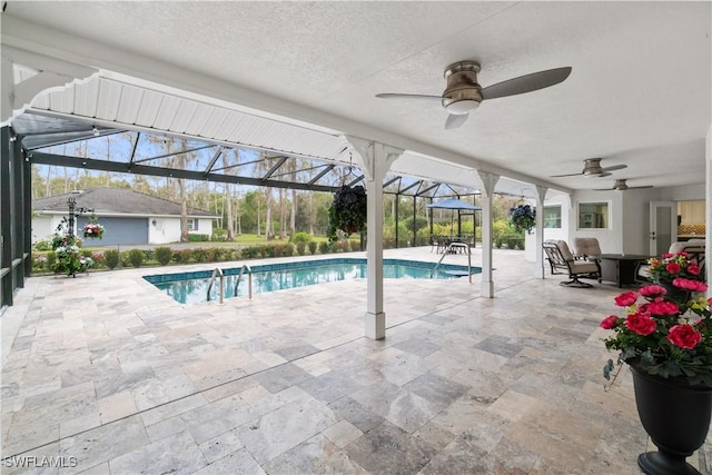 view of pool featuring ceiling fan, a patio, and glass enclosure