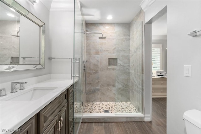 bathroom with walk in shower, vanity, toilet, and crown molding