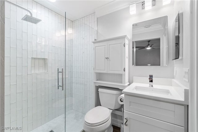 bathroom featuring an enclosed shower, vanity, toilet, ceiling fan, and crown molding