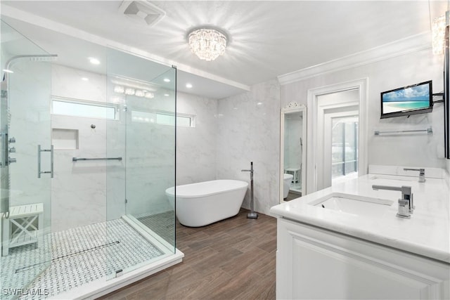 bathroom with an inviting chandelier, crown molding, separate shower and tub, and vanity