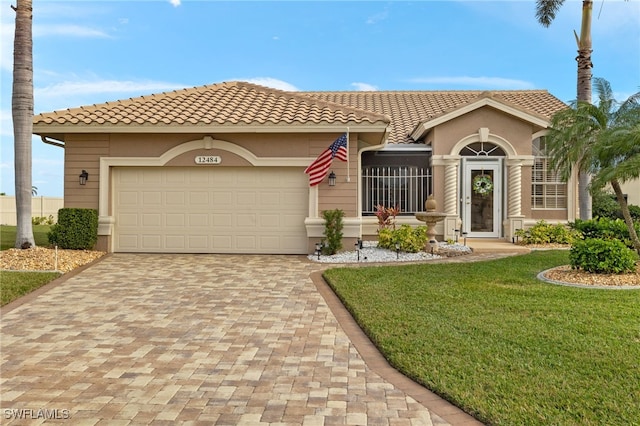 mediterranean / spanish home featuring a garage and a front lawn