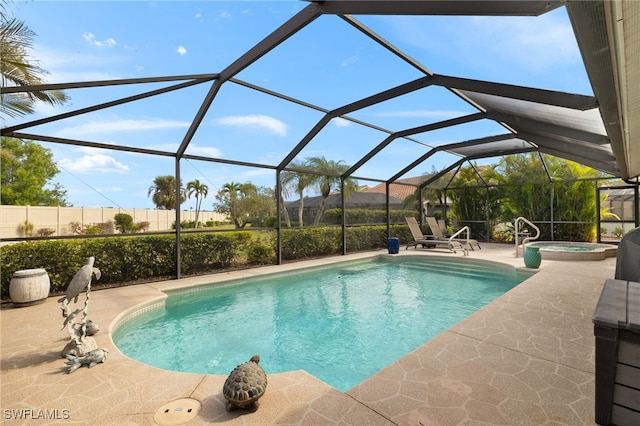 outdoor pool with an in ground hot tub, a patio, fence, and glass enclosure