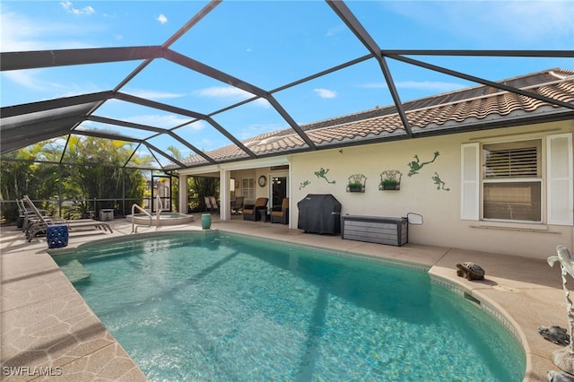 outdoor pool featuring a patio area, an in ground hot tub, grilling area, and glass enclosure