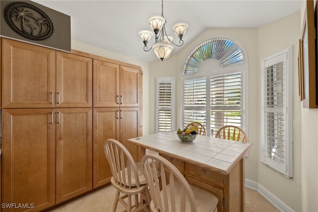 dining space with lofted ceiling, light tile patterned floors, baseboards, and a notable chandelier