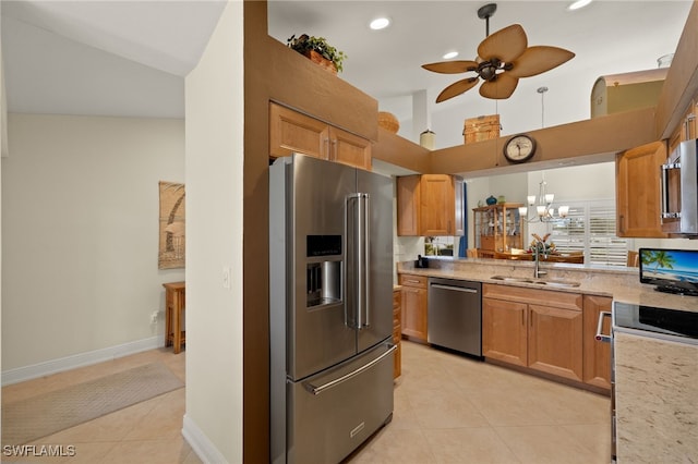 kitchen featuring light tile patterned floors, lofted ceiling, stainless steel appliances, a sink, and ceiling fan with notable chandelier