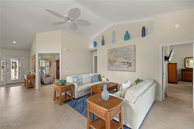 living area featuring lofted ceiling, ceiling fan, and light tile patterned floors