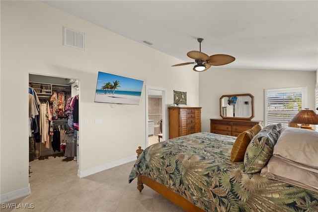 bedroom featuring a walk in closet, a closet, visible vents, and vaulted ceiling