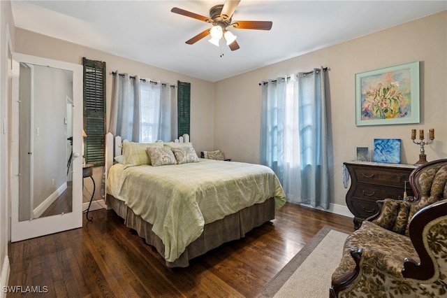 bedroom featuring dark wood-type flooring, ceiling fan, and multiple windows