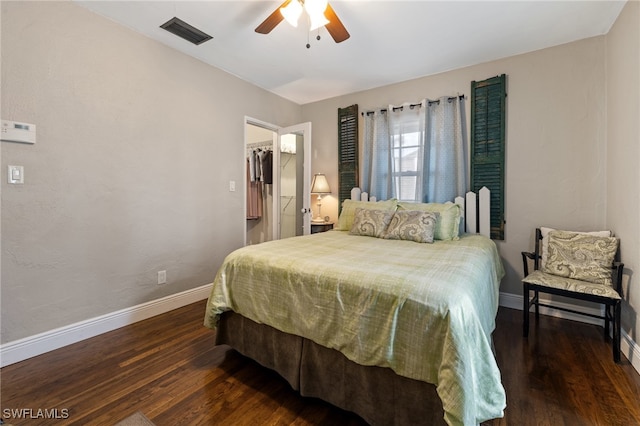 bedroom with a walk in closet, dark hardwood / wood-style floors, and ceiling fan