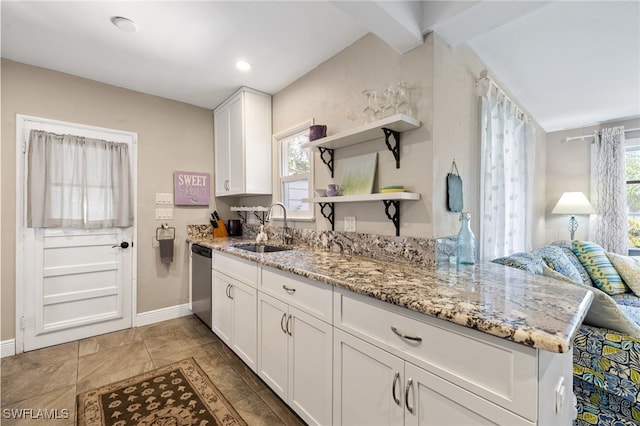 kitchen featuring sink, white cabinetry, light stone counters, stainless steel dishwasher, and kitchen peninsula