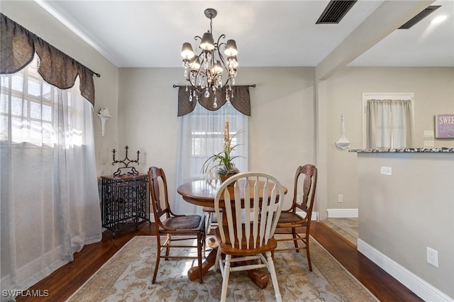 dining space with an inviting chandelier and dark hardwood / wood-style floors