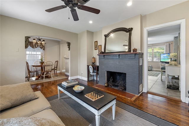 living room featuring hardwood / wood-style flooring and ceiling fan with notable chandelier