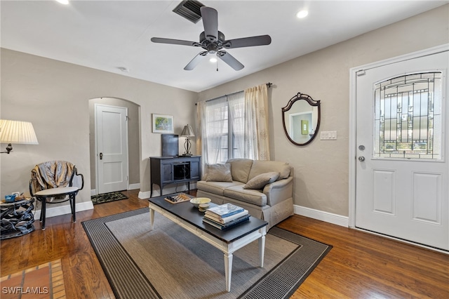 living room featuring dark wood-type flooring and ceiling fan