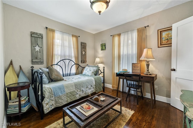 bedroom with dark hardwood / wood-style floors