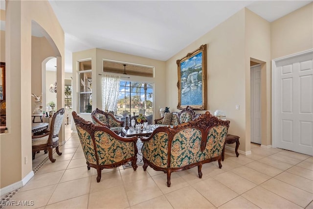 dining area with arched walkways, baseboards, and light tile patterned floors