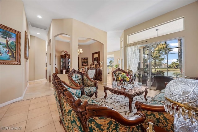 tiled living room featuring a notable chandelier