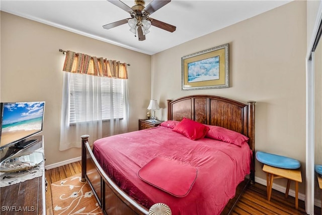 bedroom with ceiling fan, baseboards, and dark wood-type flooring