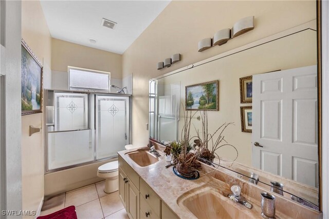 full bathroom featuring tile patterned flooring, vanity, enclosed tub / shower combo, and toilet