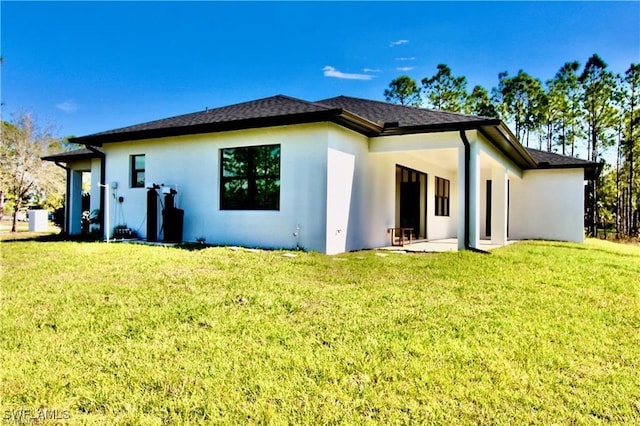 rear view of house with a patio and a lawn