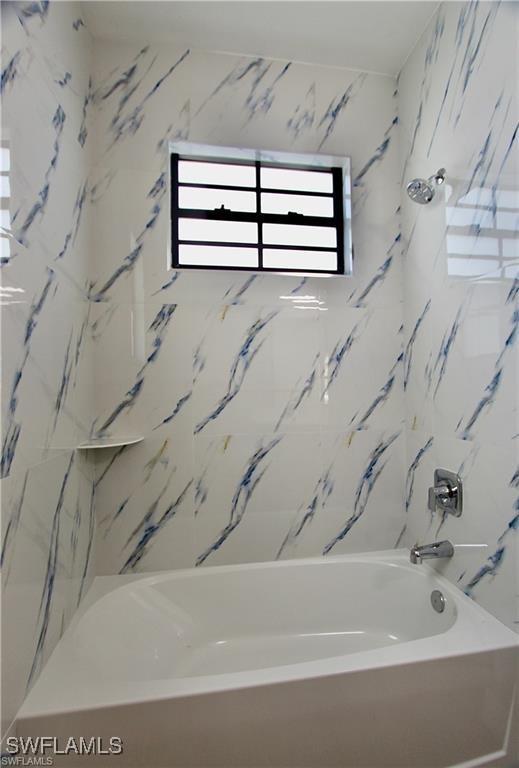 bathroom featuring tiled shower / bath