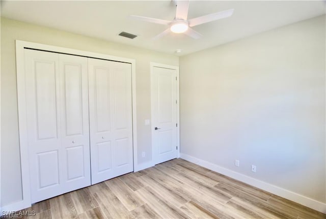 unfurnished bedroom featuring ceiling fan, light wood-type flooring, and a closet