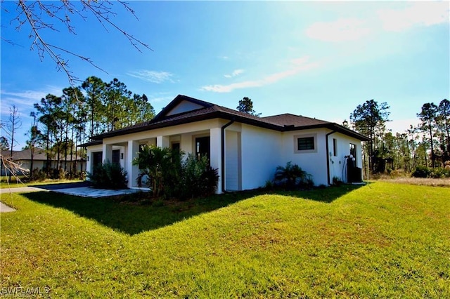 view of side of home with a lawn