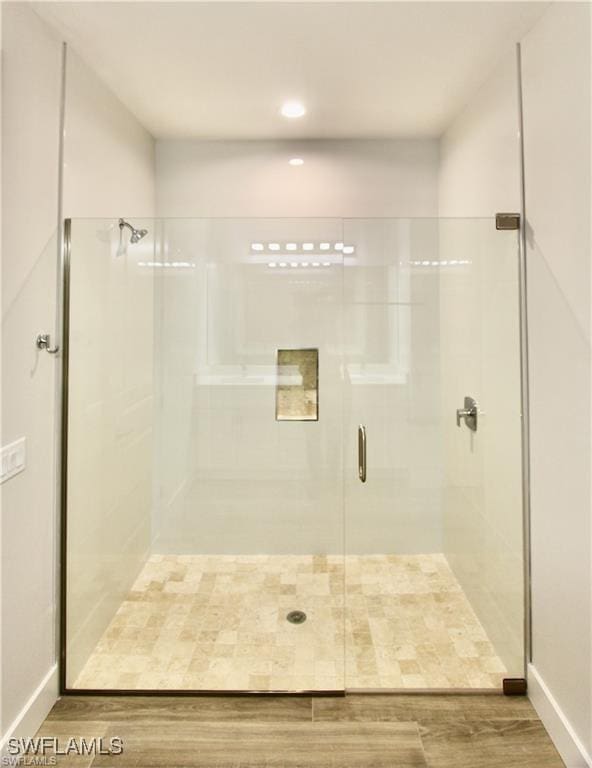 bathroom featuring a shower with shower door and hardwood / wood-style floors