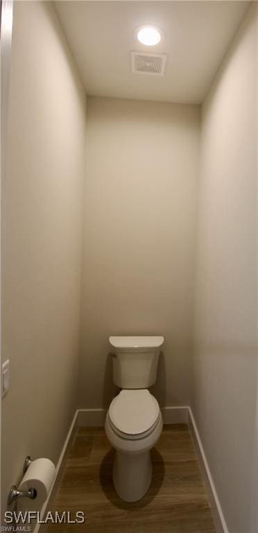 bathroom with hardwood / wood-style flooring and toilet