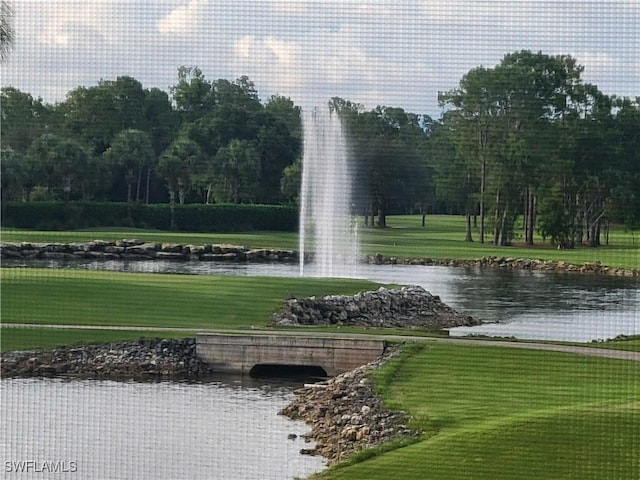 surrounding community with a water view and a yard