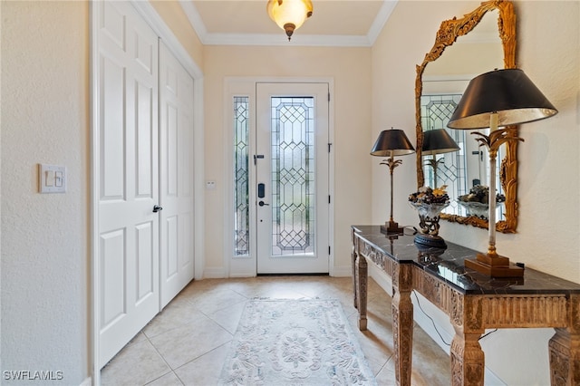 tiled foyer entrance with ornamental molding and a healthy amount of sunlight