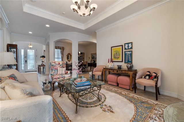 tiled living room featuring a chandelier, ornamental molding, and a raised ceiling