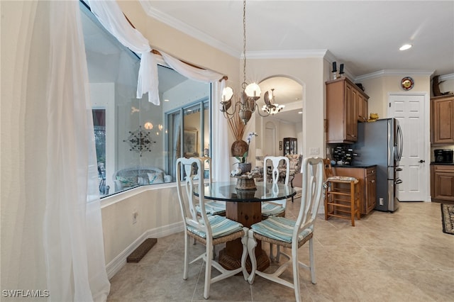 dining space with light tile patterned floors, ornamental molding, and a notable chandelier