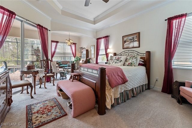 bedroom with a raised ceiling, light carpet, and ceiling fan with notable chandelier