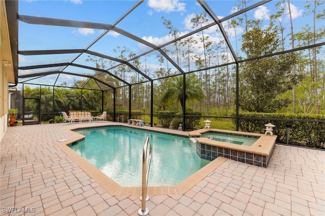 view of pool featuring a pool with connected hot tub, a lanai, and a patio area