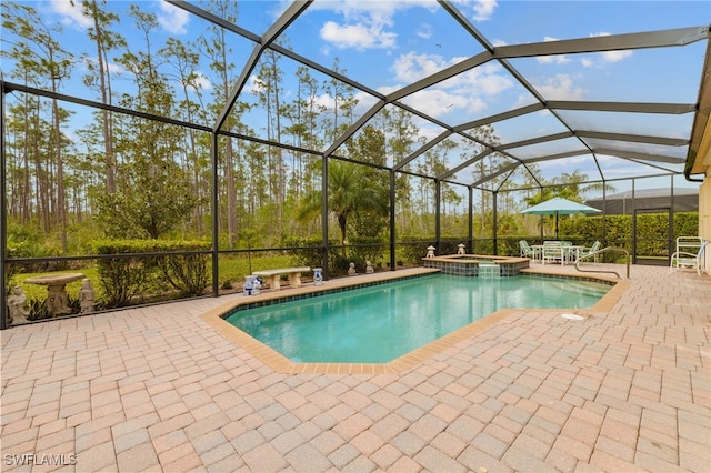 view of swimming pool with a pool with connected hot tub, glass enclosure, and a patio