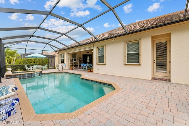 view of swimming pool with a pool with connected hot tub, glass enclosure, and a patio area