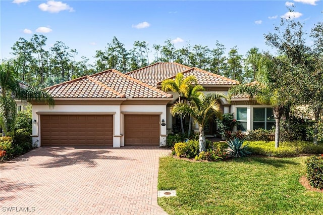 mediterranean / spanish-style home featuring a front lawn and a garage