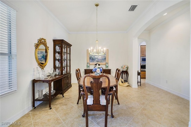 dining room featuring visible vents, arched walkways, ornamental molding, and an inviting chandelier