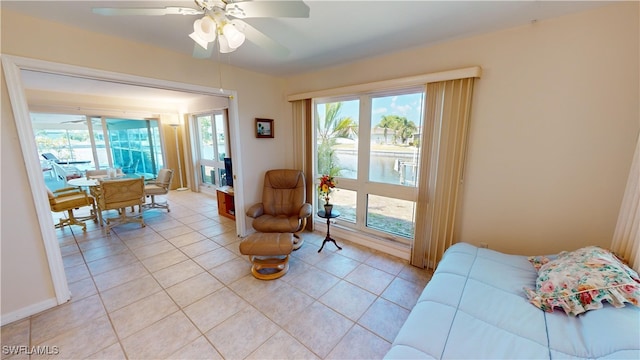 living area featuring ceiling fan and light tile patterned floors