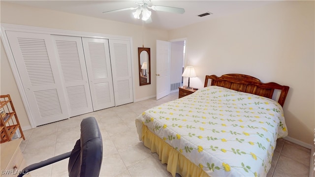 tiled bedroom featuring ceiling fan and a closet