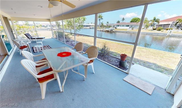 sunroom / solarium featuring a water view, ceiling fan, and plenty of natural light