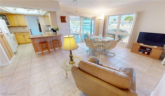 tiled living room featuring plenty of natural light and a tray ceiling