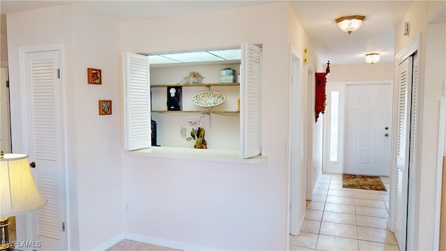 hall featuring light tile patterned floors