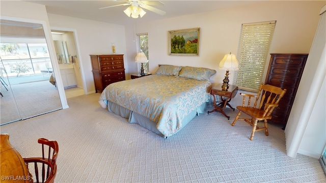 carpeted bedroom featuring ceiling fan and ensuite bath