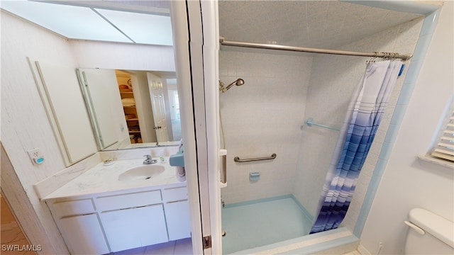 bathroom featuring toilet, vanity, and curtained shower